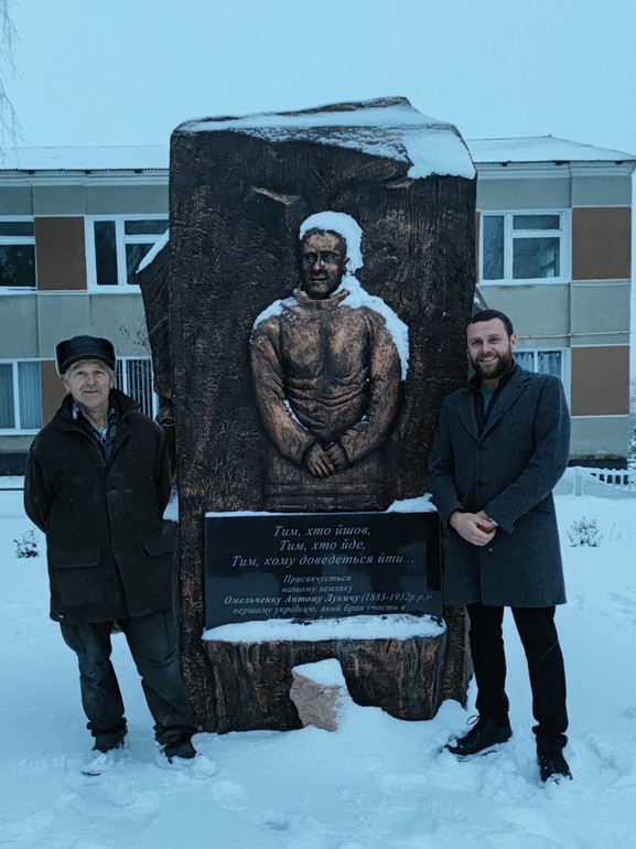 Віктор та Антон Омельченки біля пам'ятника засновнику їхньої антарктичної династії Антону Омельченку в с.Батьки на Полтавщині