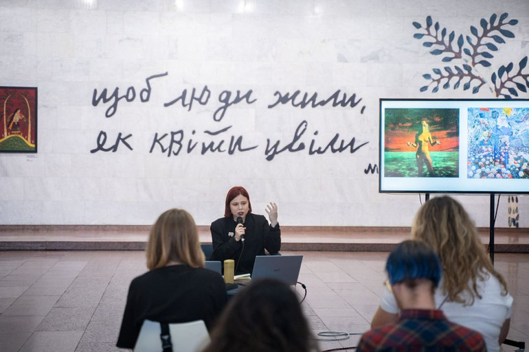 Оксана Семенік презентує лекцію про мисткиню на виставці Марії Примаченко в Українському домі.