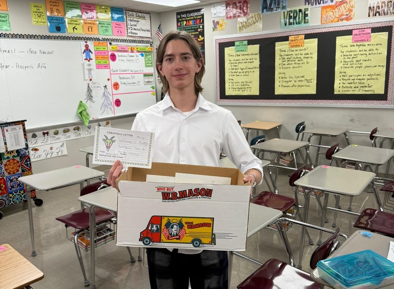 Арсеній у своїй школі з коробкою листів для українських військових