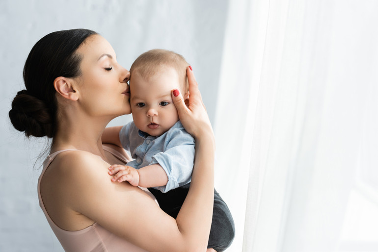 A baby touches a mother