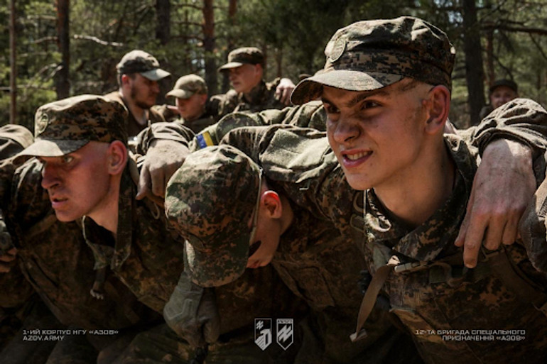 Військові у камуфляжі під час спільного тренування в лісі.
