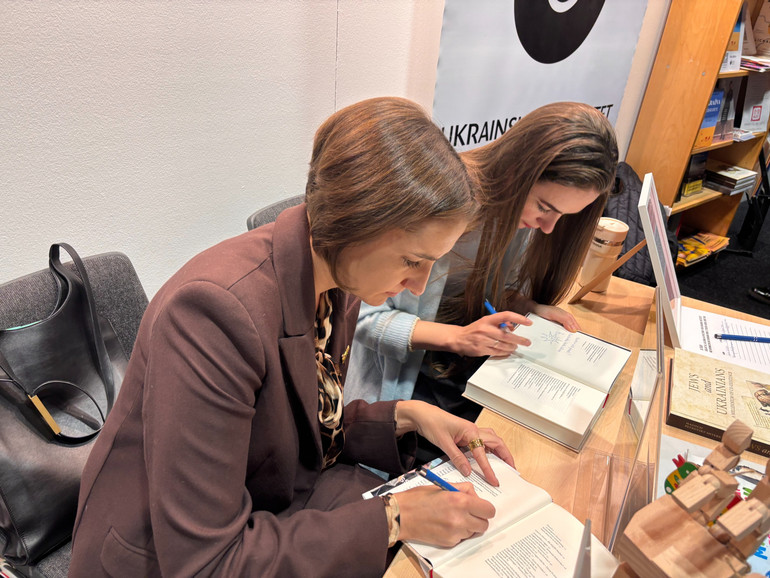 Тетяна Терен та Олександра Матвійчук підписують книжку Вікторії Амеліної її читачам