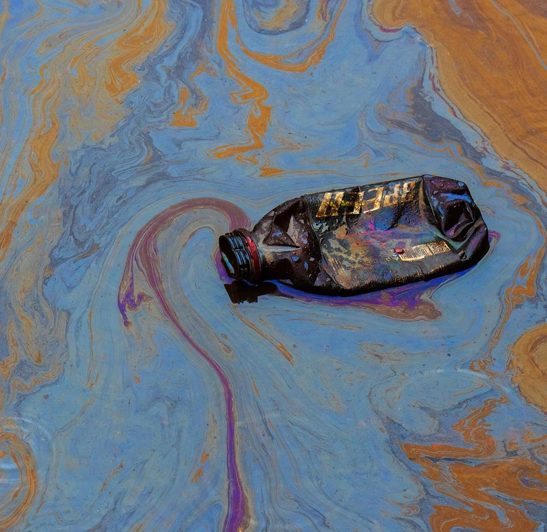 Пляшка в калюжі з нафти