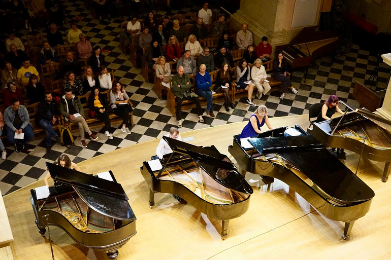 Four grand pianos on the stage of the organ hall