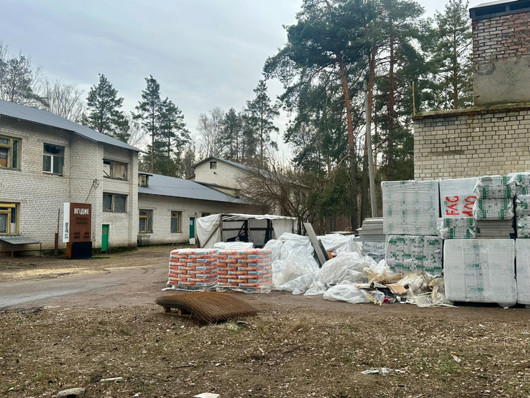 Двір школи заставлений будівельними матеріалами, але вони не для школи, а відновлення будинків в селі. В самій школі — вибиті вікна і немає кому їх полагодити