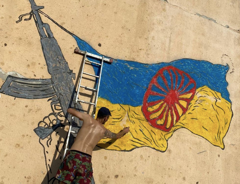Мурал в Ужгороді за ескізом Нікіти Кравцова, присвячений участі ромів в лавах ЗСУ та боротьбі проти російської агресії. 2022. Ужгород. Створено під час резиденції Вибачте, номерів немає.