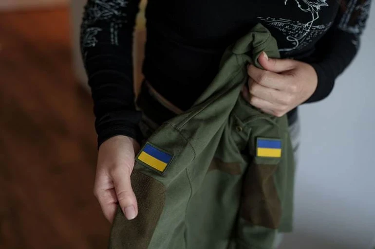 Уляна показує форму свого чоловіка Влада у своїй квартирі в Києві, Україна, 29 травня 2026 року.