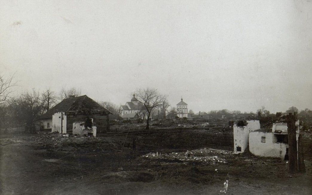 Посеред згарища видніється вціліла дзвінниця церкви.