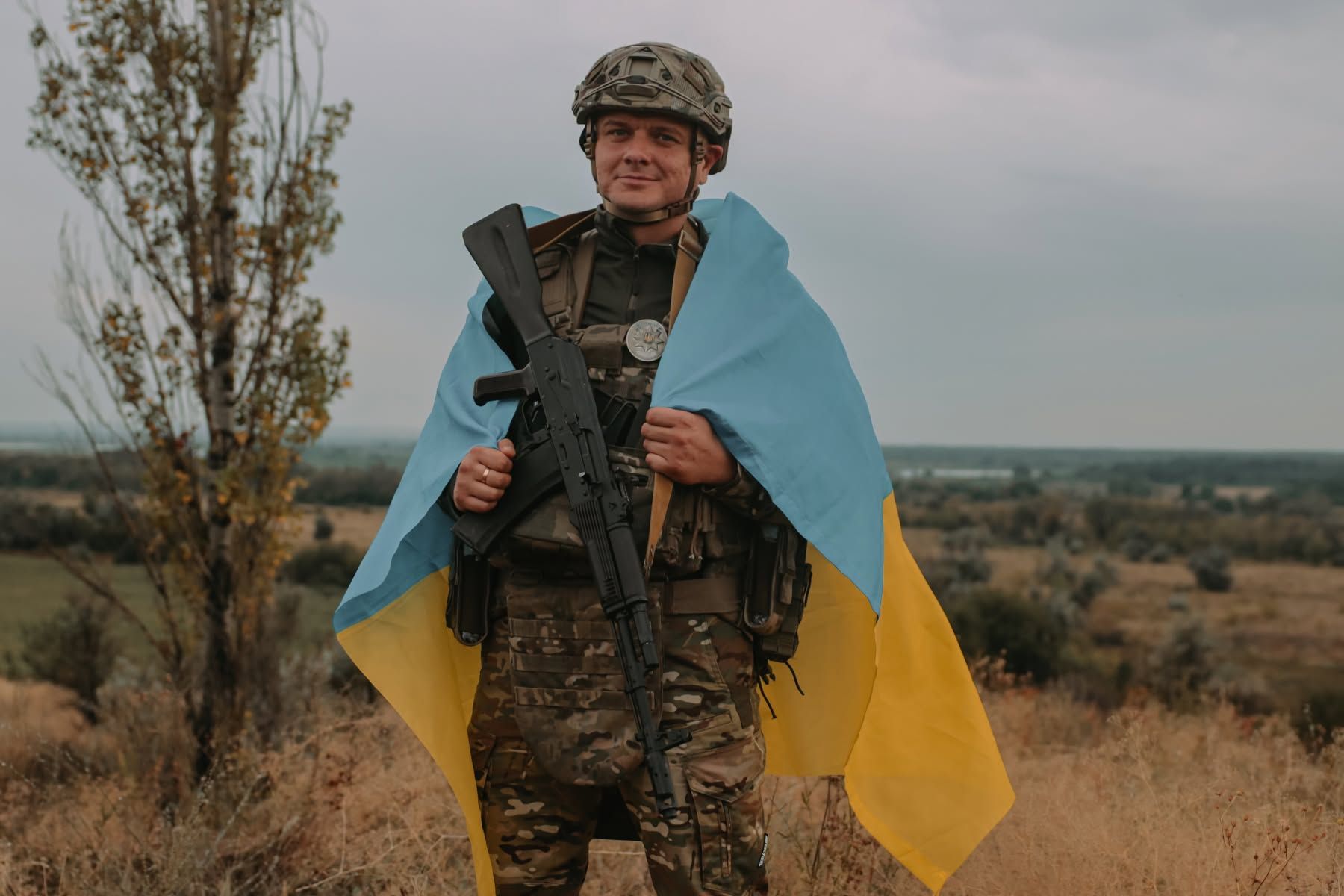 Українських воїн вкривається державним прапором