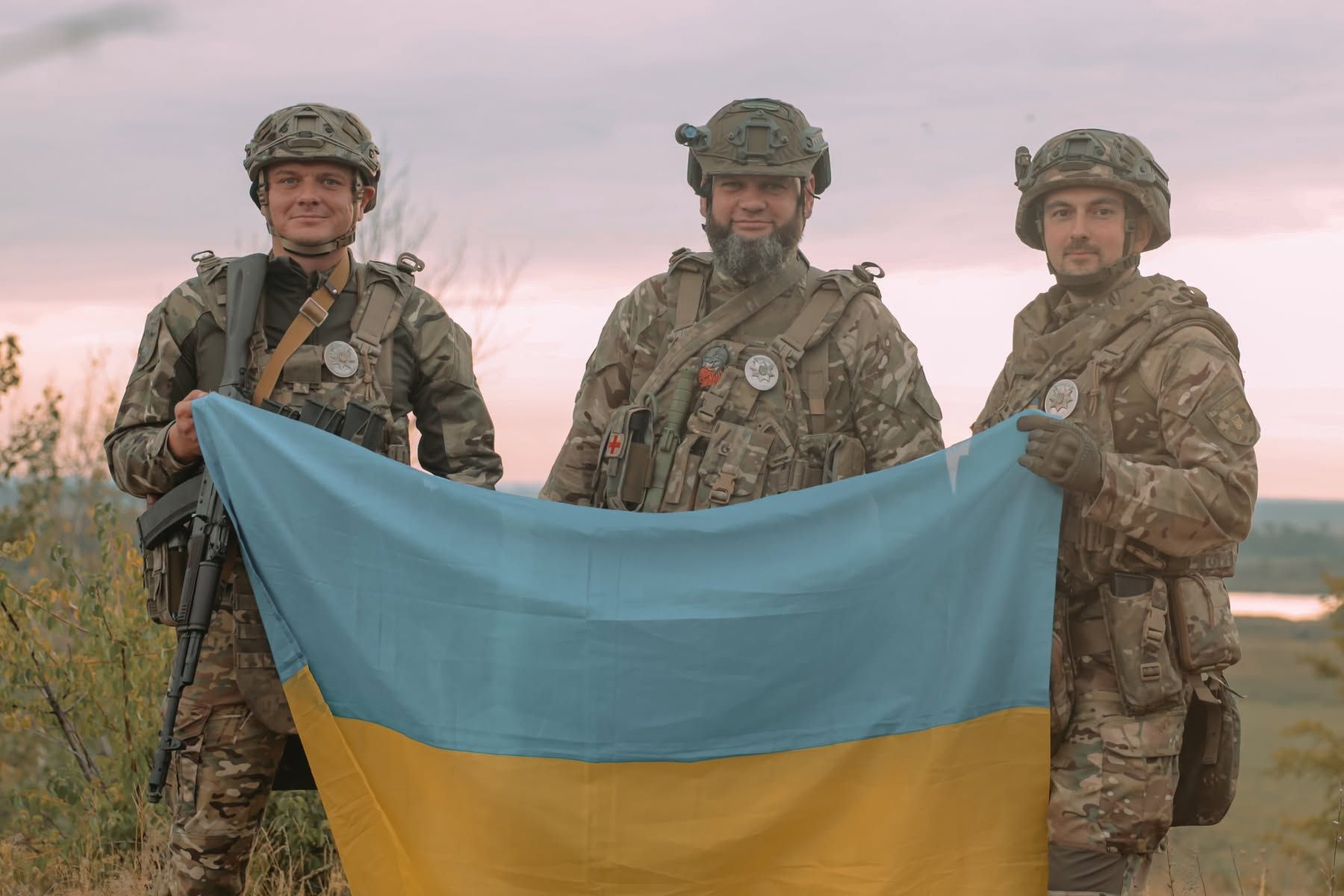 Троє українських бійців із прапором